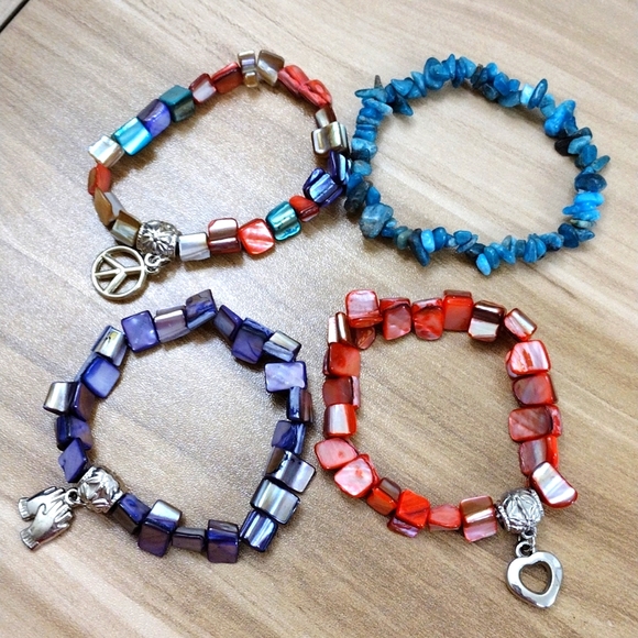 Jewelry - Set of four stretch shell bracelets with silver tone charm